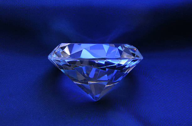 Blue diamond on satin stock photo