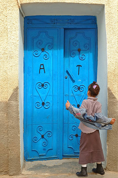Blue door - A child knocking on the door tunisian girls stock pictures, royalty-free photos & images