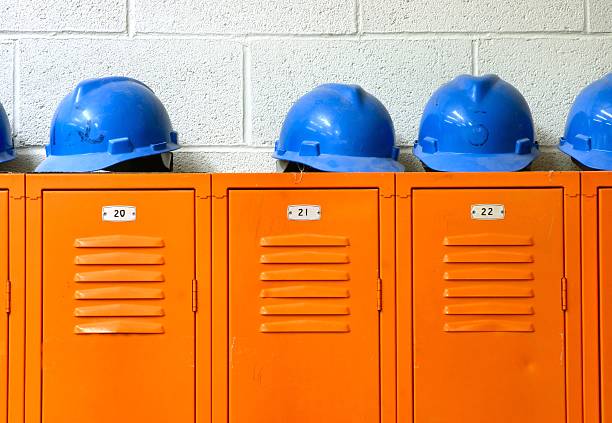 Blue Hard Hats on top of orange Lockers stock photo