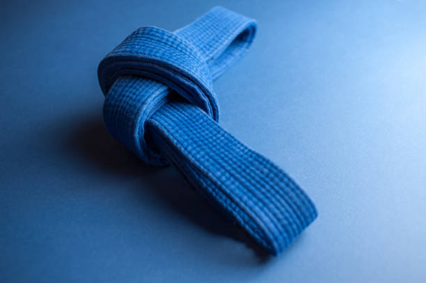 Blue judo belt isolated on blue background Blue judo belt tied in a knot isolated on blue background bushido lifestyle stock pictures, royalty-free photos & images