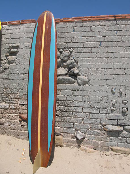 Blue longboard surfboard leaning against wall. stock photo