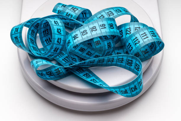 Blue measuring tape and weight scales. Blue measuring tape and weight scales. obesity stock pictures, royalty-free photos & images