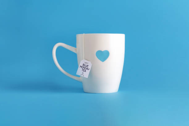 голубой понедельник чай. белая чашка на синем. - blue monday стоковые фото и изображения
