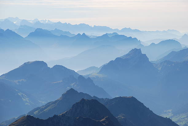 Blue mountain ranges silhouette Swiss alps and fog altostratus stock pictures, royalty-free photos & images