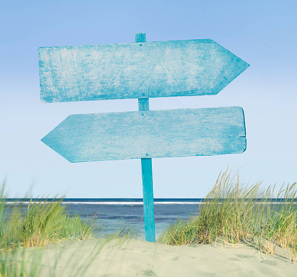 blue painted wood label on beach - strandbordjes stockfoto's en -beelden