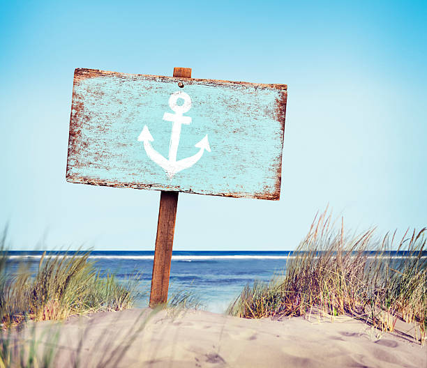 blue painted wood label on the beach - strandbordjes stockfoto's en -beelden