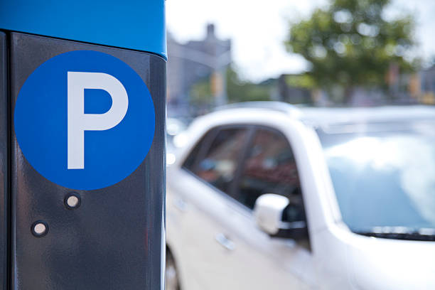 A blue parking ticket machine beside the road  stock photo