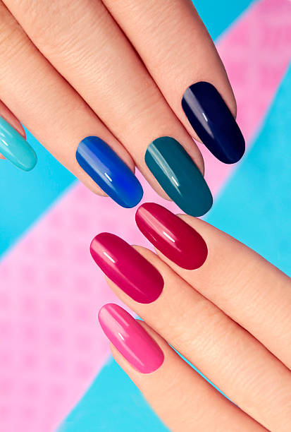 Blue pink nail Polish. Blue pink nail Polish on long nails on a colored background. gel nail polish stock pictures, royalty-free photos & images