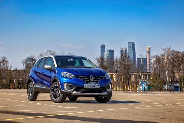 Blue Renault Kaptur with a gray roof. The two-tone compact crossover is parked on the street. Front view stock photo