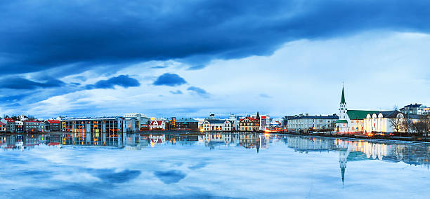 Blue Reykjavik Beautiful panorama of the skyline cityscape of Reykjavik, reflected in lake Tjornin at the blue hour in winter reykjavik stock pictures, royalty-free photos & images