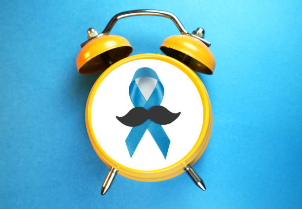 Blue Ribbon prostate cancer awareness ribbon with mustache on alarm clock. Prevention time concept. stock photo
