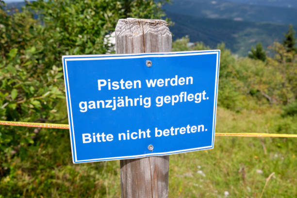 Blue sign in front of a ski slope in summer stock photo