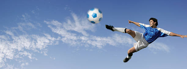 Blue sky over flying soccer player jersey foot stock pictures, royalty-free photos & images