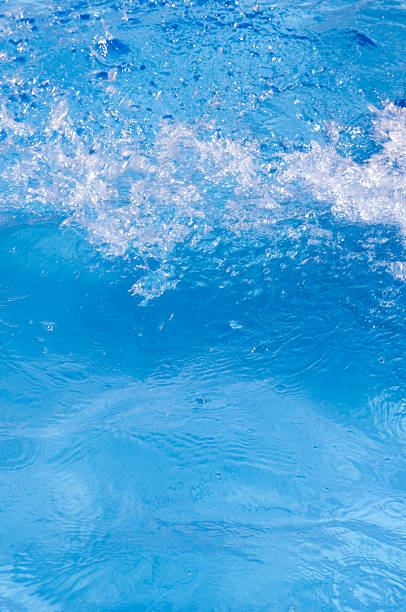 Blue splashing fresh water in pool stock photo