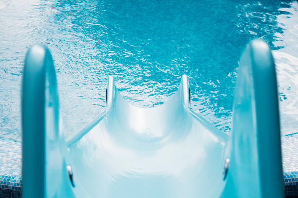 Blue swimming pool with water slide stock photo
