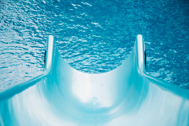Blue swimming pool with water slide stock photo