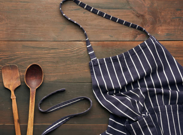 blue textile kitchen apron with white stripes and wooden spoons blue textile kitchen apron with white stripes and wooden spoons, top view apron stock pictures, royalty-free photos & images