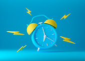 istock Blue vintage ringing alarm clock with bright yellow lightings 1388703028