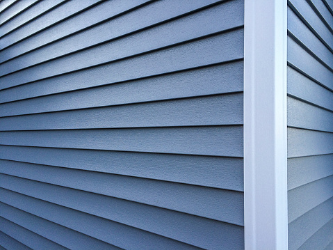 Photography of new, blue vinyl siding on a home.