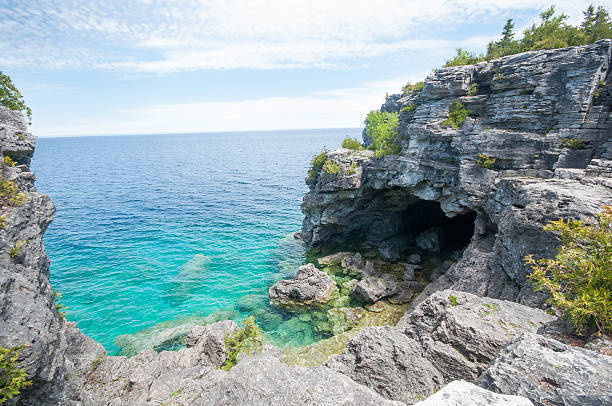 Blue water Rocky grotto beach Rocky Grotto (Bruce peninsula  trail), with clear blue water and blue sky. Rocky beach bruce peninsula stock pictures, royalty-free photos & images