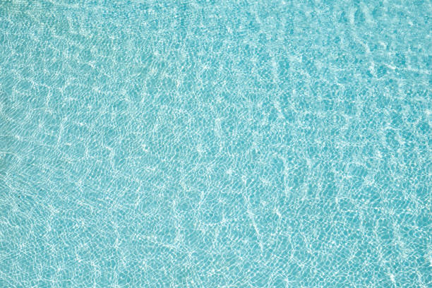Blue water surface and sun reflection in swimming pool stock photo