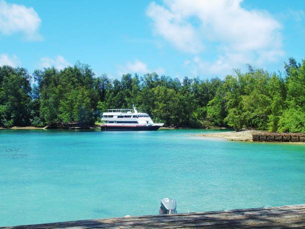 Blue waters of a lagoon with a yacht moored in the waters in Peleliu, Palau. stock photo
