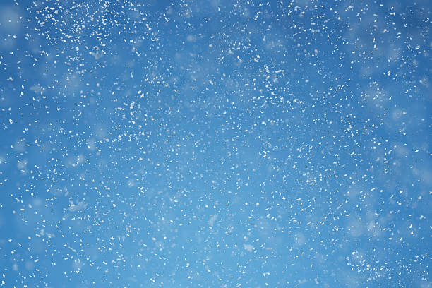 Blue winter background with tint white snow flakes stock photo