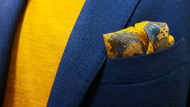 blue wool jacket over a mustard cashmere polo shirt and a matching yellow silk pocket square or handkerchief - hernemode stockfoto's en -beelden