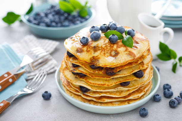 pancake ai mirtilli con burro, sciroppo d'acero e bacche fresche. colazione americana - pancake foto e immagini stock