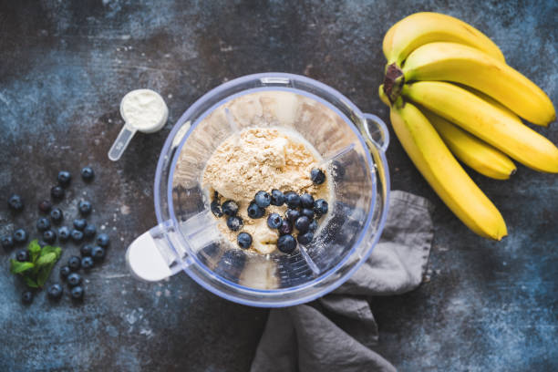 Blueberry protein smoothie Blueberry protein powder in blender, smoothie preparation, top view. Concept of fitness healthy eating, clean eating, sport lifestyle cream dairy product photos stock pictures, royalty-free photos & images