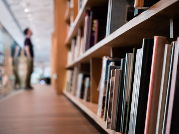 Blur People stand Book shelf in Public Library Blur People stand Book shelf in Public Library Education concept bookstore stock pictures, royalty-free photos & images