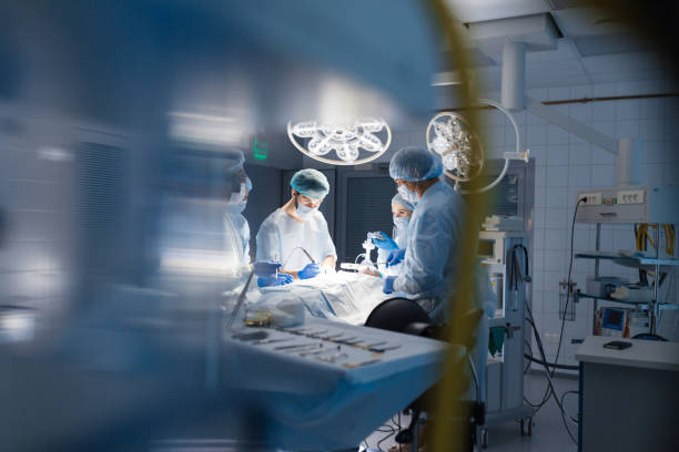 verschwommener hintergrund mit team-chirurg bei der arbeit im operationssaal - operation stock-fotos und bilder