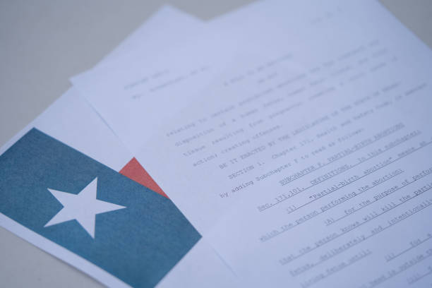 vista borrosa en primer plano de la ley de aborto de texas (tx sb8) junto a la bandera del estado de texas. - texas abortion fotografías e imágenes de stock