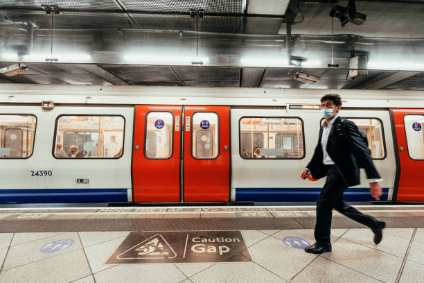 Blurred motion of man walking on London underground subway platform stock photo
