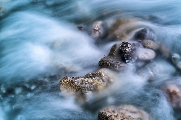 Photo of blurred river motion water and stones