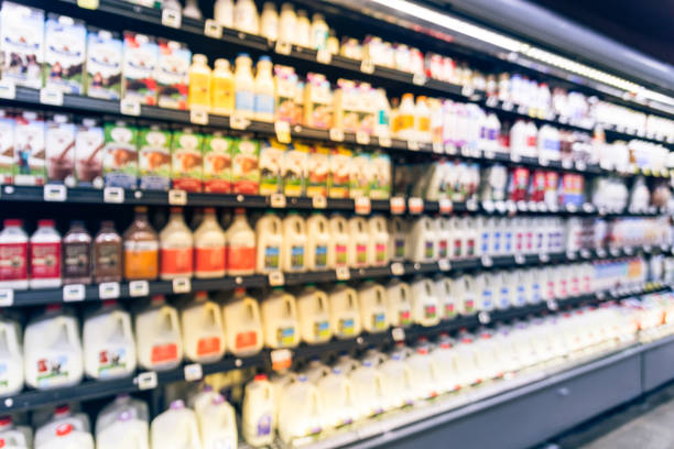 Blurred selection of dairy products in open front cold fridge stock photo