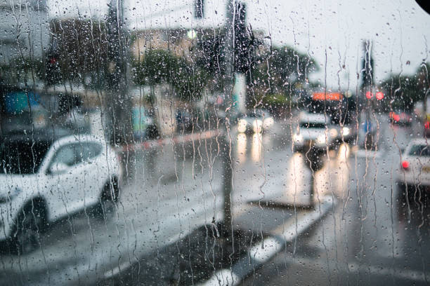 Blurred street scene through car windows with rain drop stock photo
