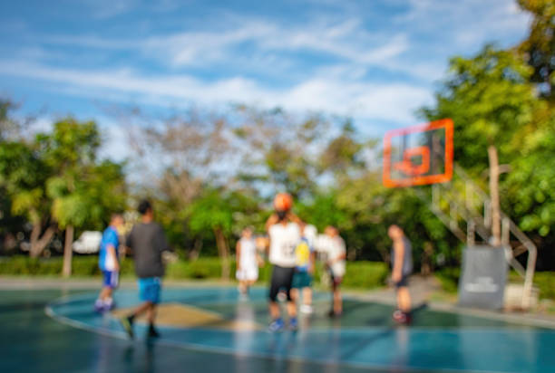 Blurry image of elderly men and teens playing basketball in the morning at BangYai Park , Nonthaburi in Thailand. stock photo