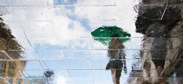 wazig reflectie silhouetten van mensen lopen op een regenachtige dag - rain woman sun stockfoto's en -beelden