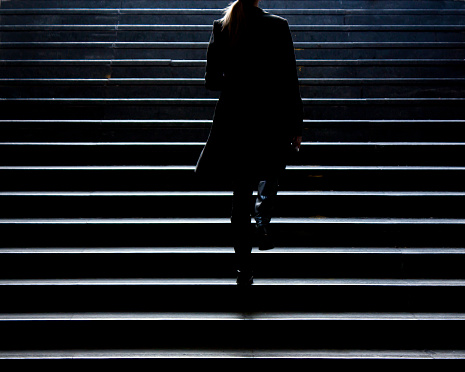 Belgrade,Serbia - December 27, 2017: Blurry silhouette of young elegant woman climbing up the stairs of underground passage in city center in winter