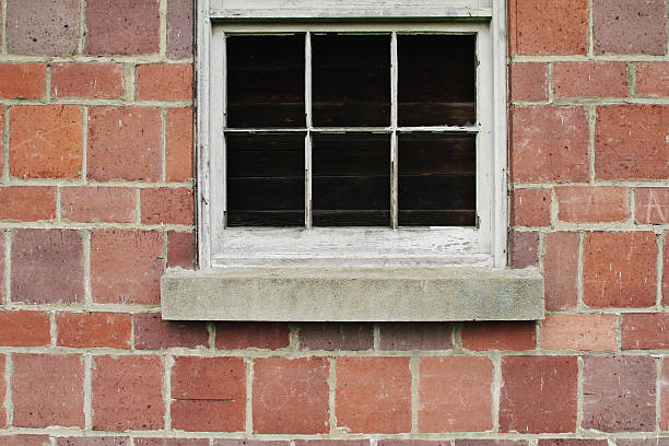 Boarded up window and a brick wall stock photo
