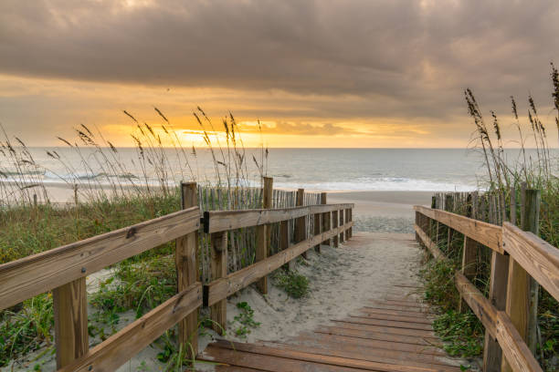 Boardwalk Leading to the Beach at Sunrise Sunrise along boardwalk over a sand dune in Myrtle Beach, South Carolina boardwalk stock pictures, royalty-free photos & images