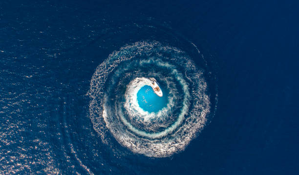 A boat is driving in a circle and produces a big whirlpool stock photo