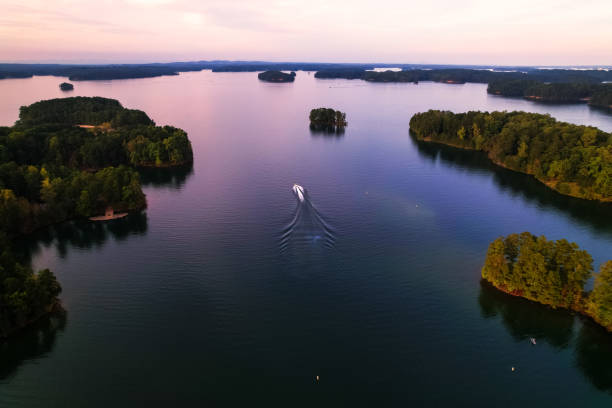boat is out on Lake Lanier at sunset stock photo