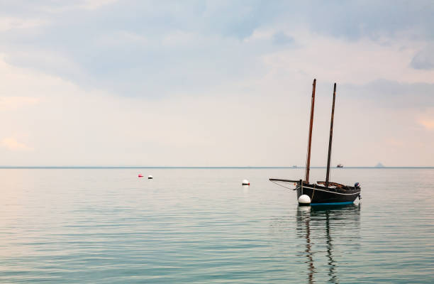 Boat reflecting in calm sea stock photo