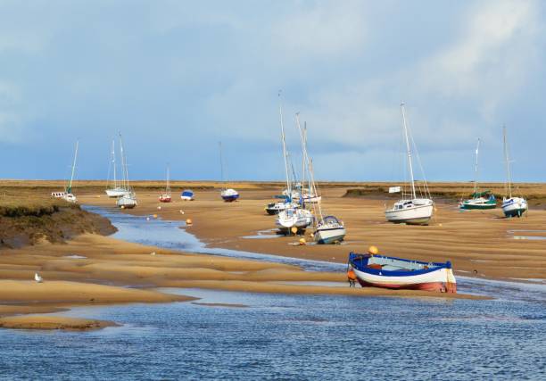 Boats At Low Tide. An image of boats at low tide on the Norfolk coast, England. low tide stock pictures, royalty-free photos & images