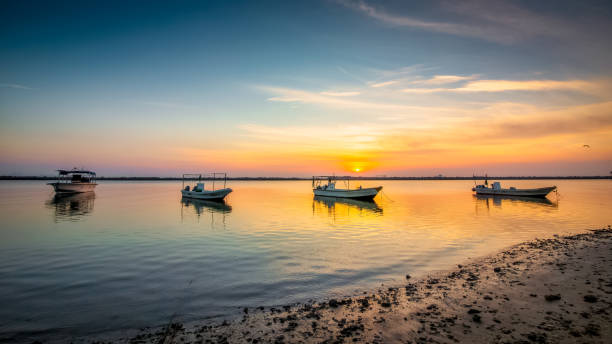 Boats on Dammam sea side with sunrise background view. Dammam, Saudi Arabia. stock photo
