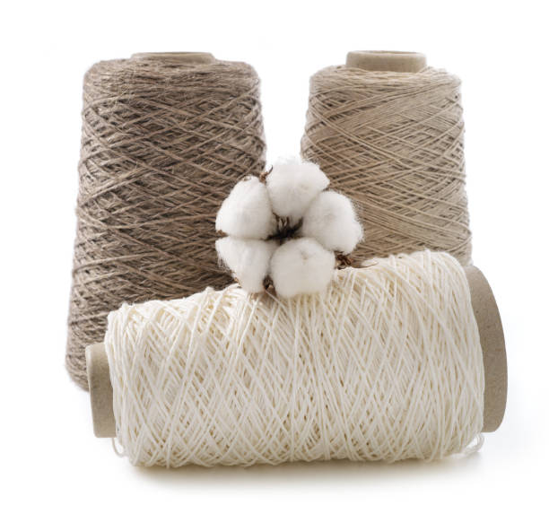 Bobbins of yarn with cotton flower stock photo