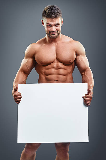 Naked Young Male Bodybuilder Holding Blank Board Stock 