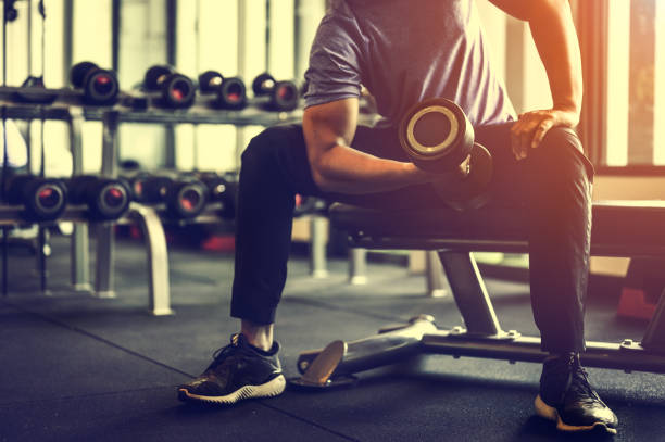 Bodybuilder working out with dumbbell weights at the gym.man bodybuilder doing exercises with dumbbell. Fitness muscular body Bodybuilder working out with dumbbell weights at the gym.man bodybuilder doing exercises with dumbbell. Fitness muscular body triceps with dumbbell stock pictures, royalty-free photos & images